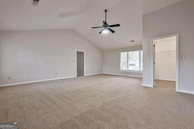 interior space with ceiling fan, vaulted ceiling, and light colored carpet