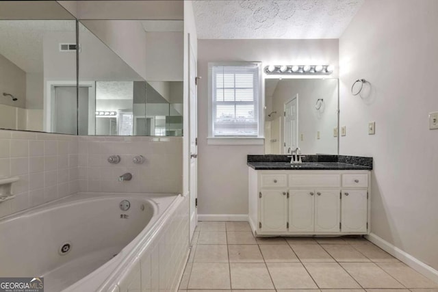 bathroom with vanity, a textured ceiling, tile patterned flooring, and a bathing tub