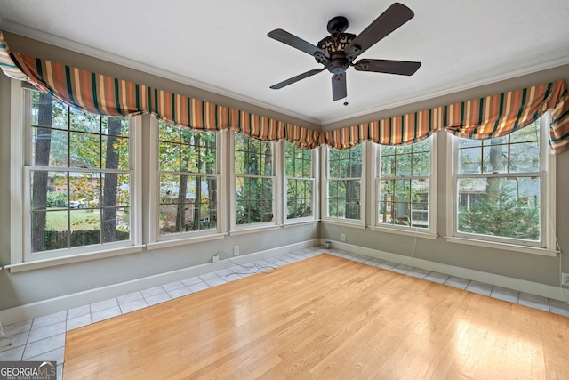 unfurnished sunroom with ceiling fan