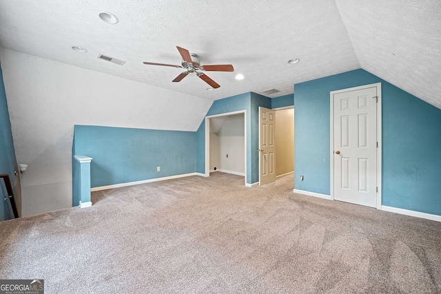 bonus room featuring carpet flooring, lofted ceiling, a textured ceiling, and ceiling fan