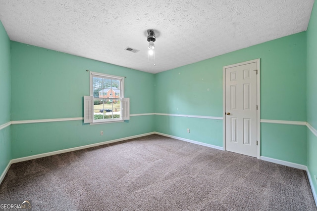 carpeted spare room featuring a textured ceiling