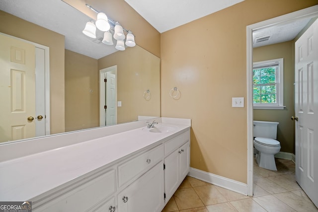 bathroom featuring toilet, vanity, a textured ceiling, and tile patterned floors