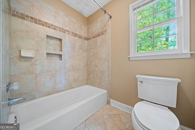 bathroom with tile patterned floors, tiled shower / bath, a textured ceiling, and toilet