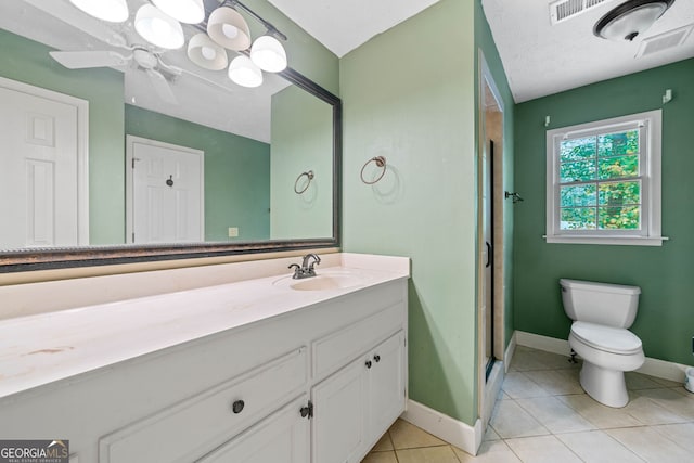 bathroom featuring a shower with door, ceiling fan, vanity, tile patterned floors, and toilet