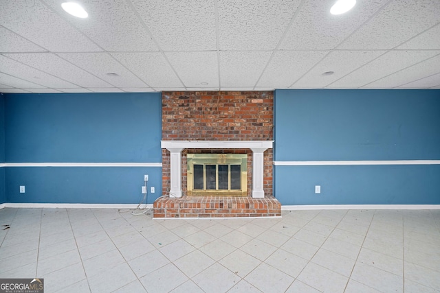 unfurnished living room with a fireplace and a paneled ceiling