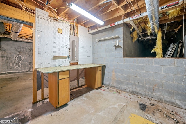 basement featuring electric panel and a workshop area