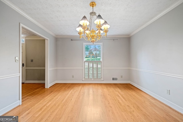 unfurnished room featuring light wood-type flooring, a notable chandelier, and crown molding