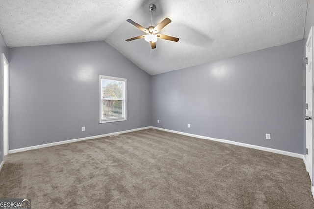 carpeted spare room with ceiling fan, lofted ceiling, and a textured ceiling