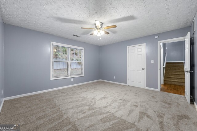 unfurnished bedroom with ceiling fan, a closet, carpet, and a textured ceiling