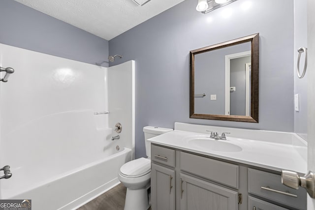 full bathroom featuring bathtub / shower combination, a textured ceiling, vanity, wood-type flooring, and toilet