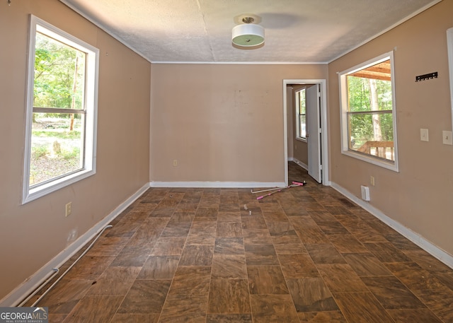 unfurnished room with a textured ceiling and a healthy amount of sunlight