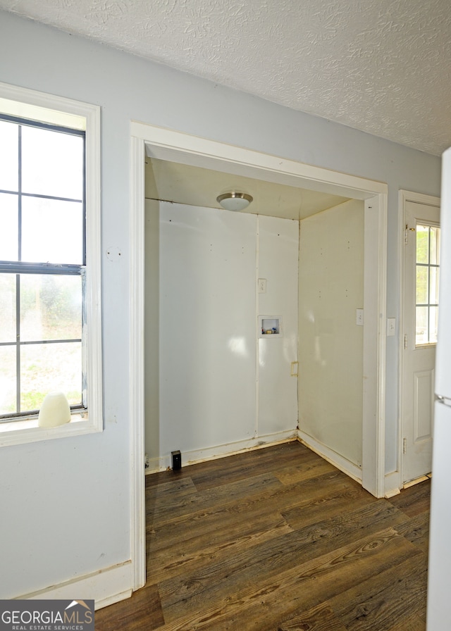 clothes washing area featuring washer hookup, plenty of natural light, dark wood-type flooring, and a textured ceiling