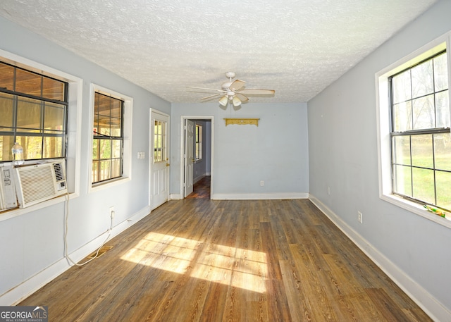 spare room with ceiling fan, cooling unit, dark hardwood / wood-style flooring, and a textured ceiling