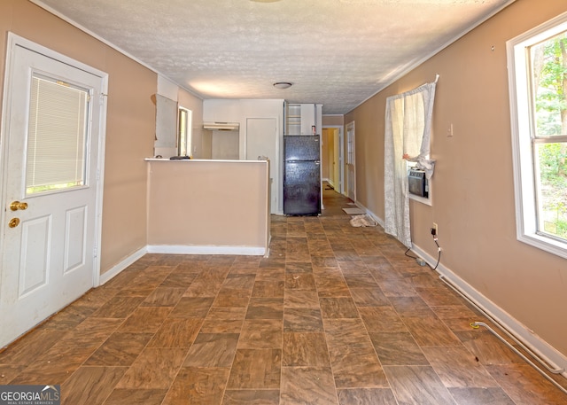 corridor featuring a textured ceiling and plenty of natural light