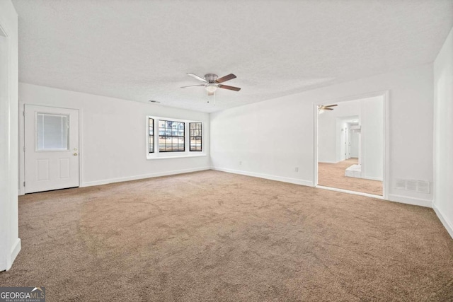 carpeted empty room featuring ceiling fan and a textured ceiling