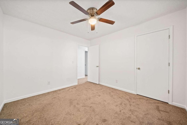 unfurnished bedroom featuring light carpet and ceiling fan