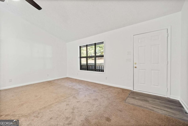 entryway featuring ceiling fan, a textured ceiling, lofted ceiling, and carpet