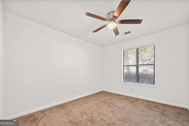 carpeted empty room featuring ceiling fan and a textured ceiling