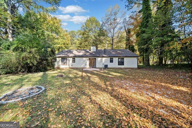 back of property featuring cooling unit and a lawn