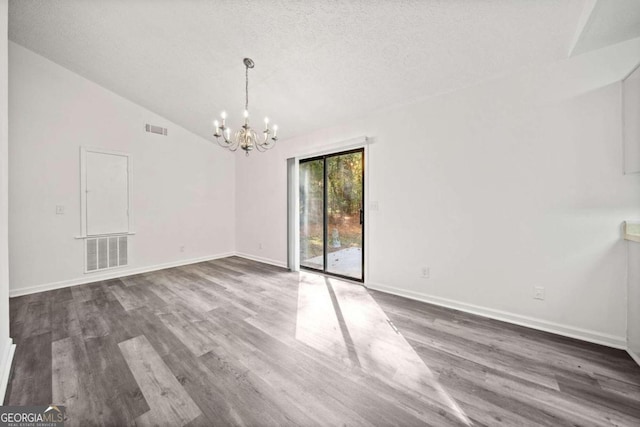 empty room featuring high vaulted ceiling, dark hardwood / wood-style flooring, a textured ceiling, and an inviting chandelier