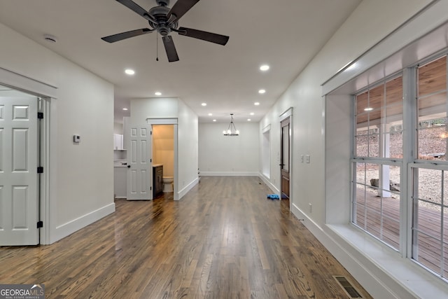 interior space with dark hardwood / wood-style floors and ceiling fan with notable chandelier