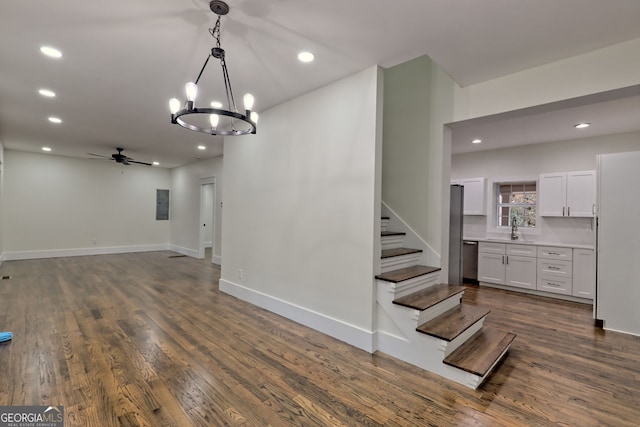 interior space with hardwood / wood-style floors, ceiling fan with notable chandelier, and sink