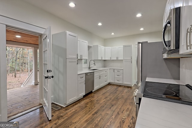 kitchen featuring white cabinets, stainless steel appliances, dark hardwood / wood-style floors, and sink