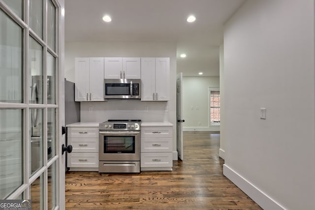 kitchen featuring white cabinetry, appliances with stainless steel finishes, and dark wood-type flooring