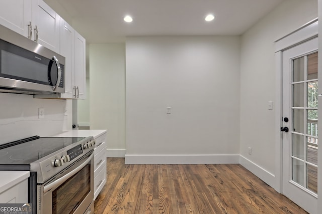 kitchen featuring white cabinetry, appliances with stainless steel finishes, and dark hardwood / wood-style floors