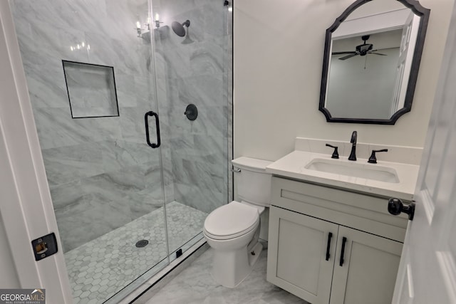 bathroom featuring ceiling fan, a shower with door, vanity, and toilet