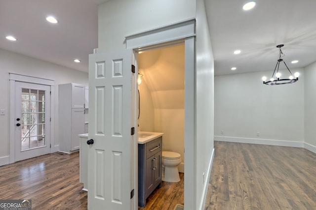 bathroom with vanity, hardwood / wood-style flooring, toilet, and a notable chandelier