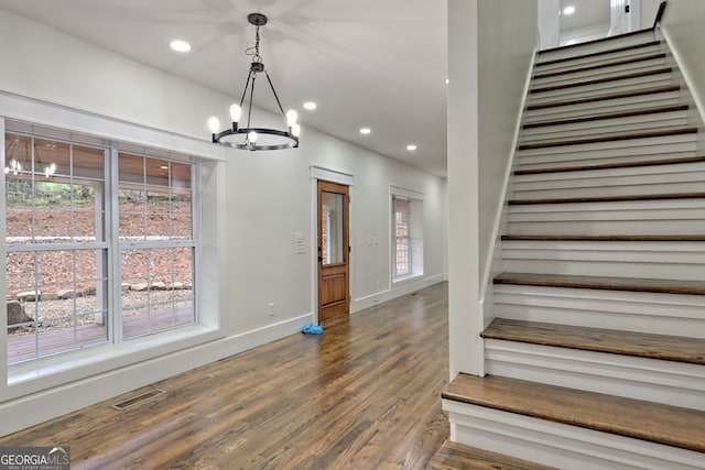 stairs with an inviting chandelier and hardwood / wood-style floors