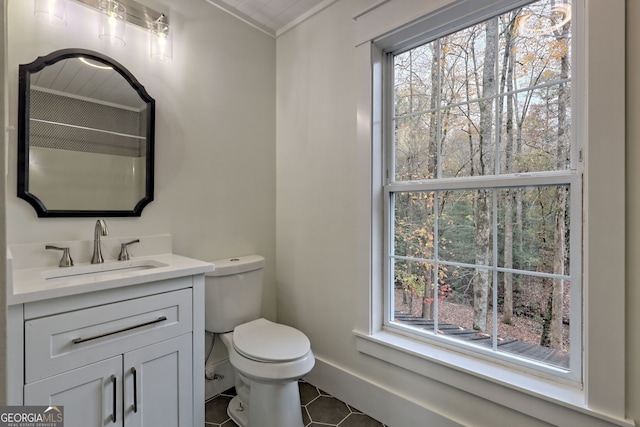 bathroom with toilet, vanity, tile patterned floors, and ornamental molding