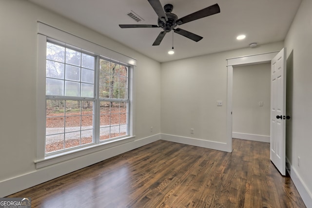 spare room with dark wood-type flooring and ceiling fan