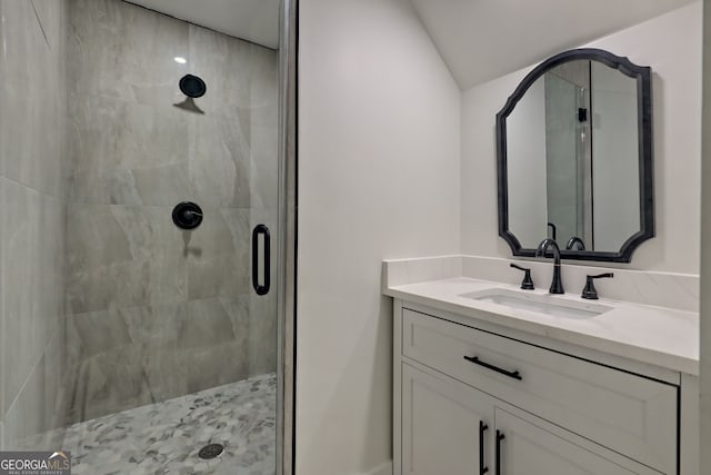 bathroom featuring walk in shower, vanity, and vaulted ceiling