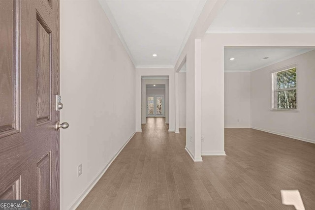 hallway with wood-type flooring and ornamental molding