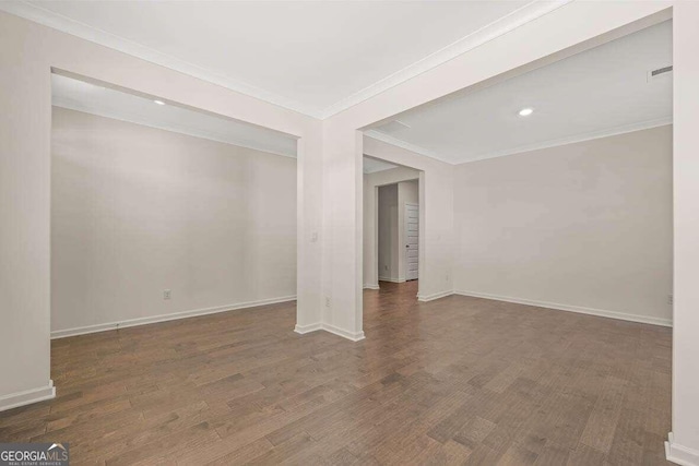 spare room featuring crown molding and dark hardwood / wood-style floors