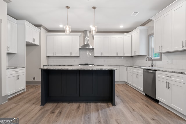 kitchen featuring dishwasher, hanging light fixtures, wall chimney range hood, light hardwood / wood-style flooring, and white cabinets