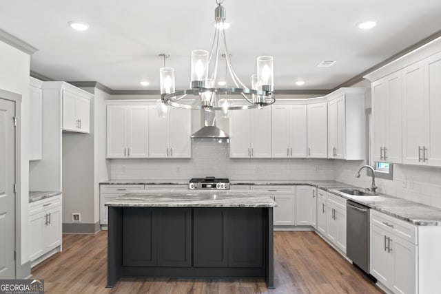 kitchen featuring white cabinets, a kitchen island, sink, and appliances with stainless steel finishes