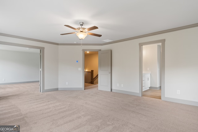 unfurnished bedroom with ceiling fan, ornamental molding, light carpet, and ensuite bath