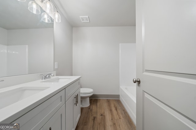 full bathroom featuring shower / bath combination, vanity, wood-type flooring, and toilet