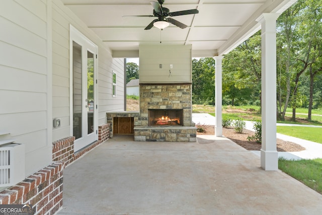 view of patio featuring an outdoor stone fireplace and ceiling fan