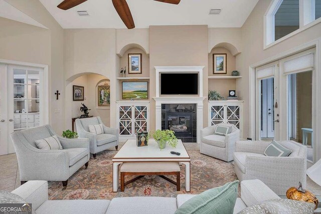 living room featuring ceiling fan and a tiled fireplace