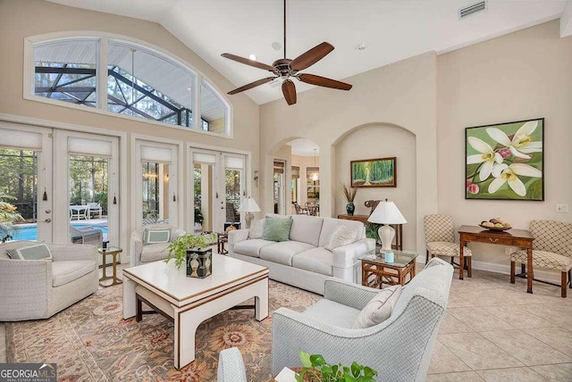 tiled living room with high vaulted ceiling, french doors, and ceiling fan