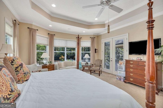 carpeted bedroom with french doors, a tray ceiling, ceiling fan, access to exterior, and multiple windows