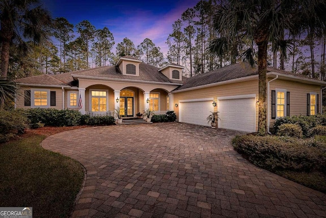 mediterranean / spanish-style home with a garage and a porch