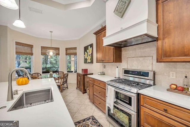 kitchen featuring sink, hanging light fixtures, decorative backsplash, custom exhaust hood, and range with two ovens