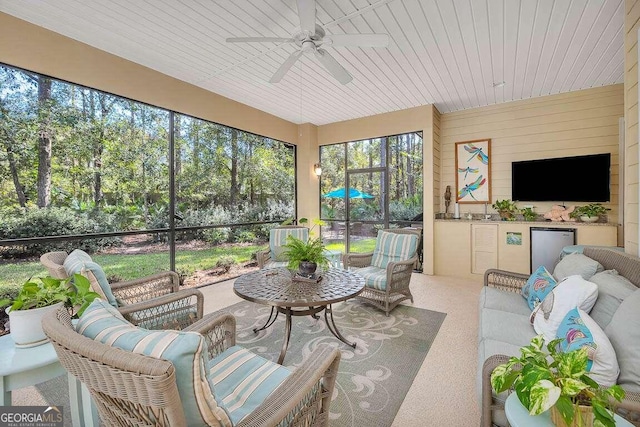 sunroom with a wealth of natural light, wooden ceiling, and ceiling fan