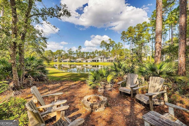 view of yard featuring a water view and a fire pit