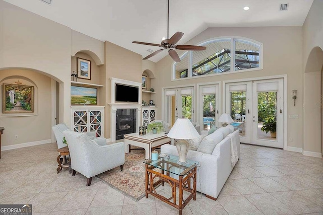 living room with light tile patterned flooring, a high ceiling, ceiling fan, built in shelves, and french doors